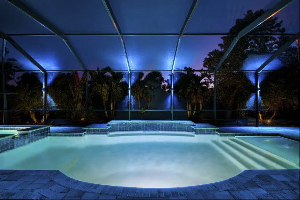LED-lit pool cage with palm trees at night — Superior Electrical specialty