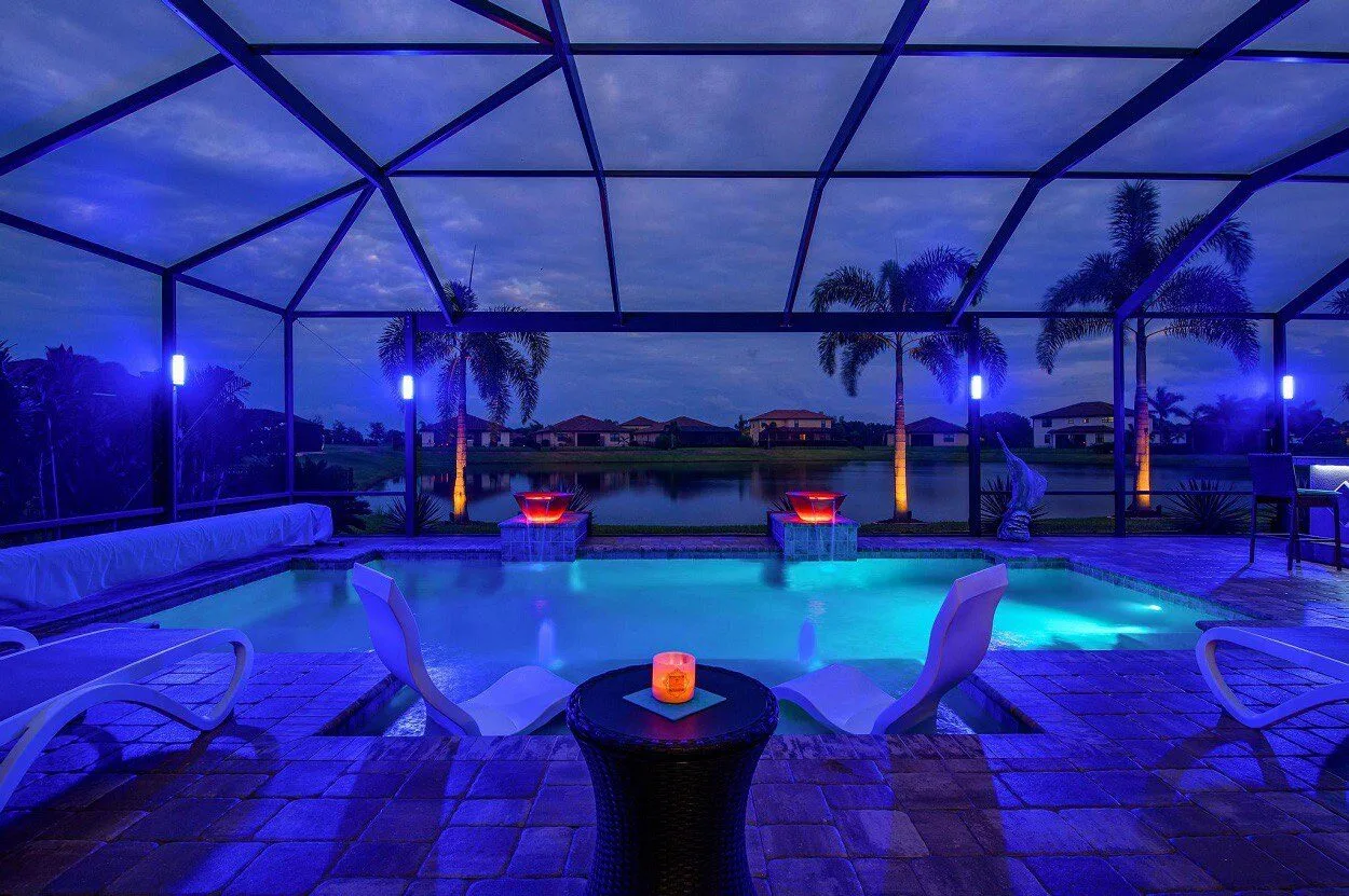 Lakefront pool cage with LED lighting and fire bowls in Bradenton