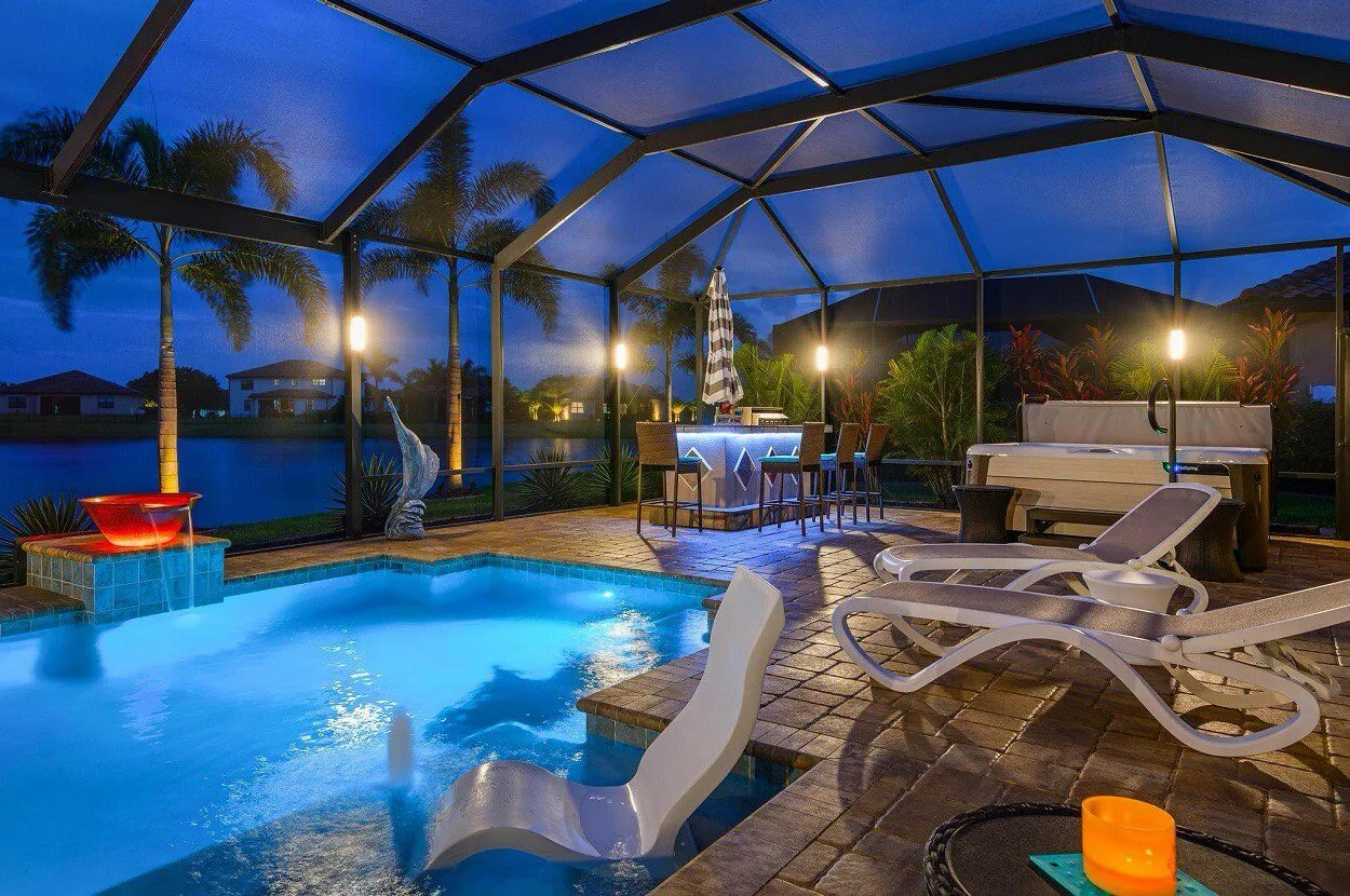 Pool cage with outdoor kitchen illuminated by blue LED strips