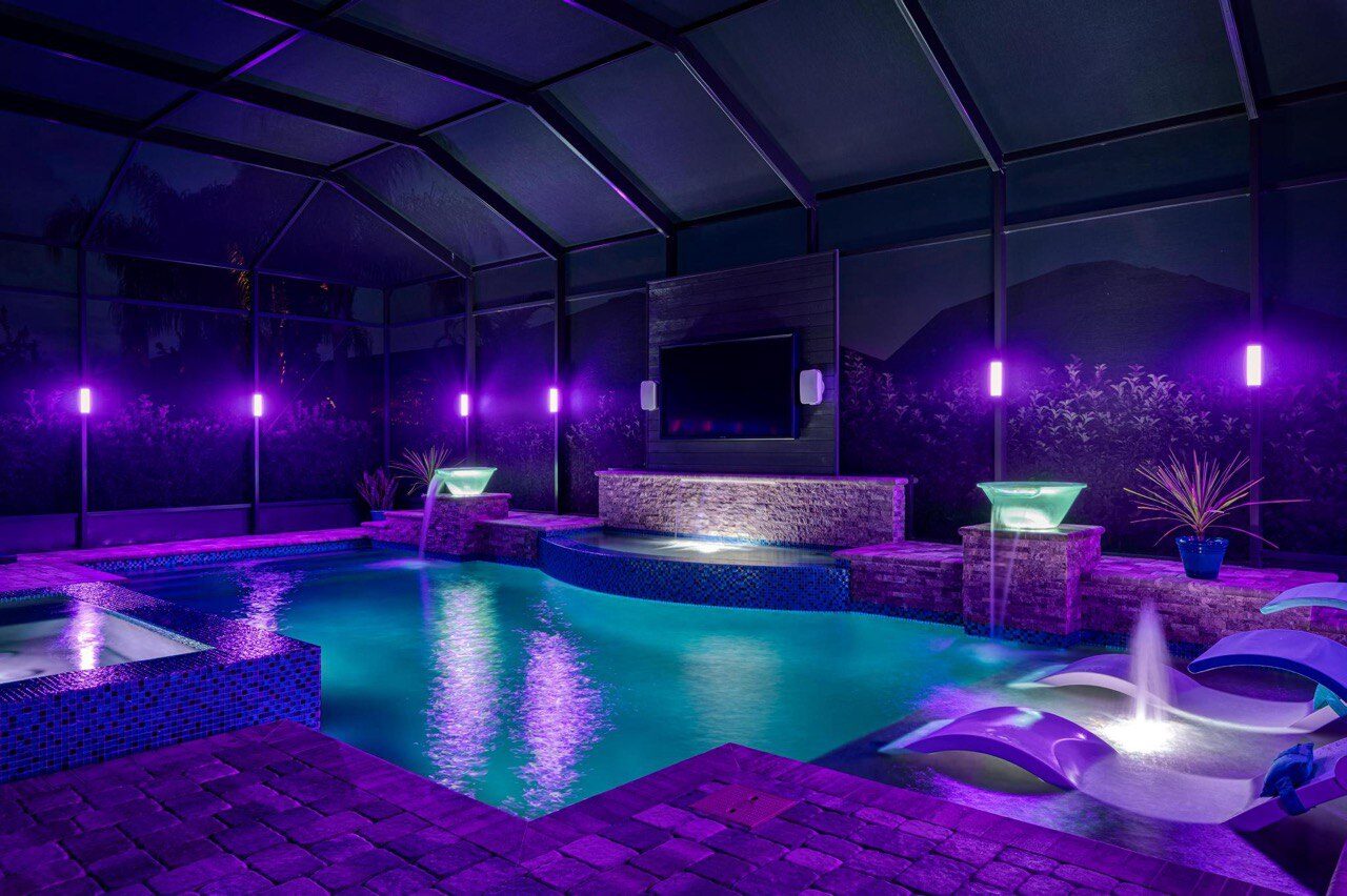 Pool cage with purple LED lighting at night